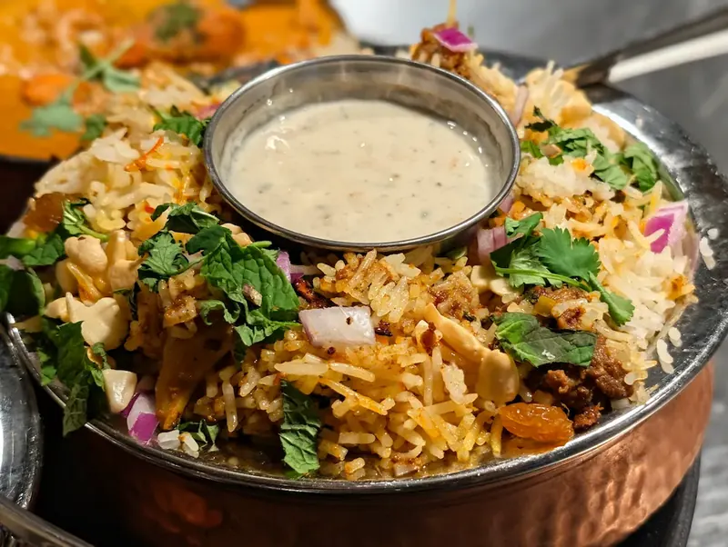 Lamb Biryani – Fragrant basmati rice layered with tender lamb, saffron, and whole spices. Our b | SPICE ROOM Denver